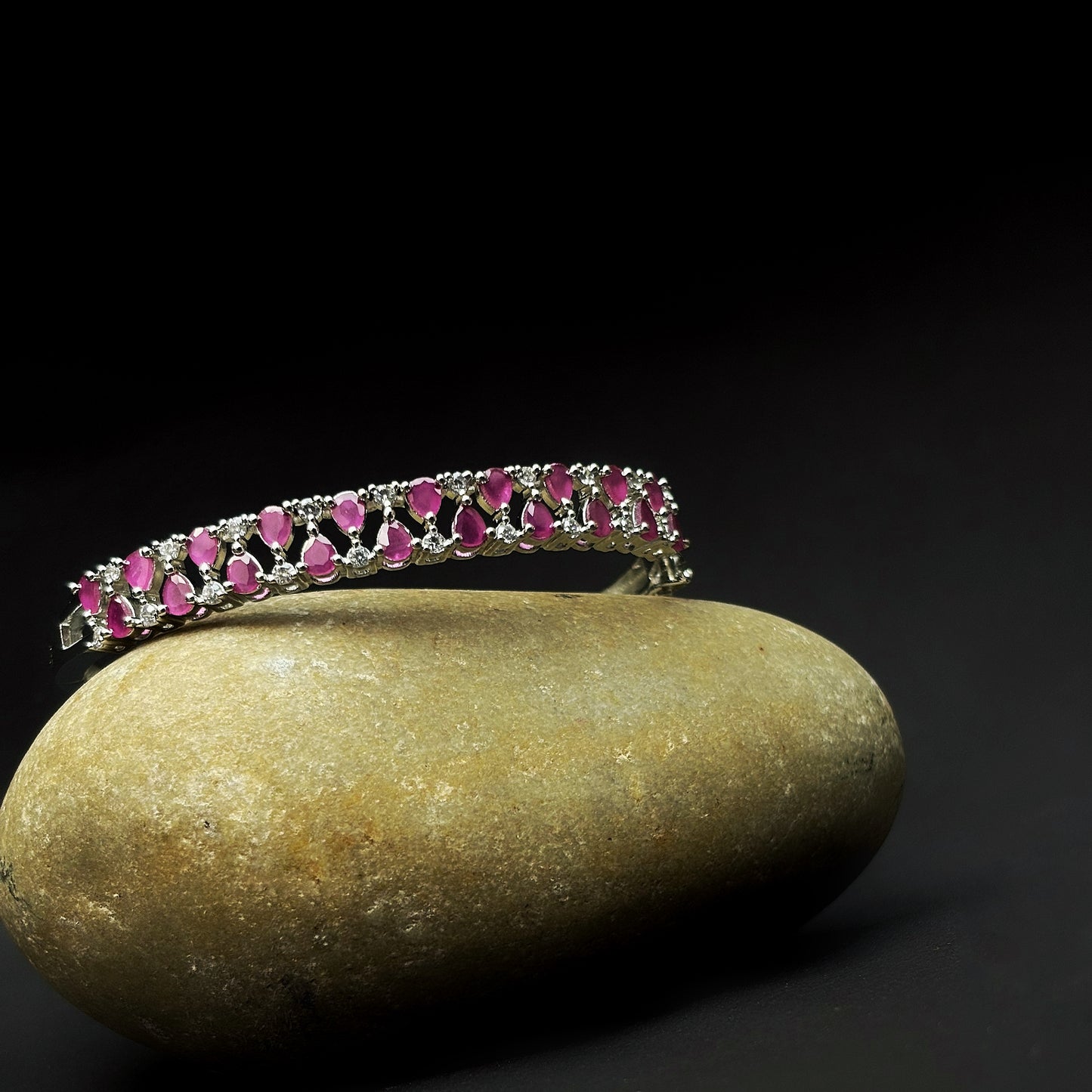 A diamond bracelet with a pink stone's by hvjewellery.in